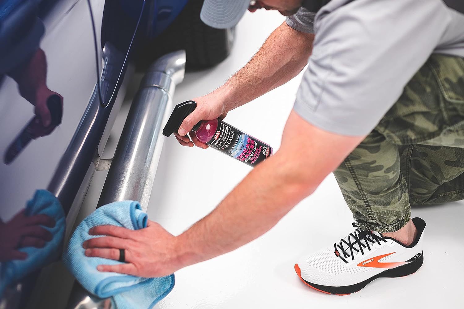 Detailer applying P&S Dream Maker Gloss Amplifier to a car's side panel, demonstrating ease of use with a microfiber towel
